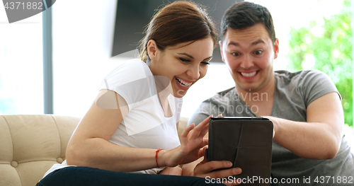 Image of Young Couple using digital tablet at home