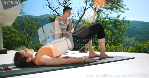 Image of Couple Doing Stretching Exercises Together in front of luxury vi