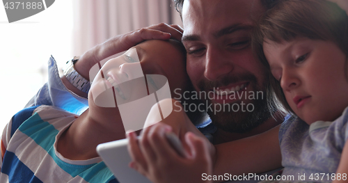 Image of father and two kids having fun together at home