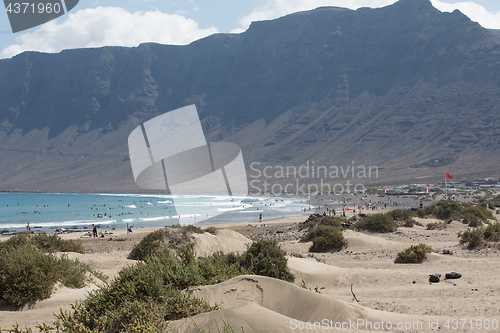 Image of The red flag weighs in the wind at Surfers Beach Famara on Lanza