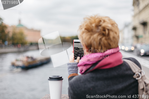 Image of Woman taking shots from waterfront