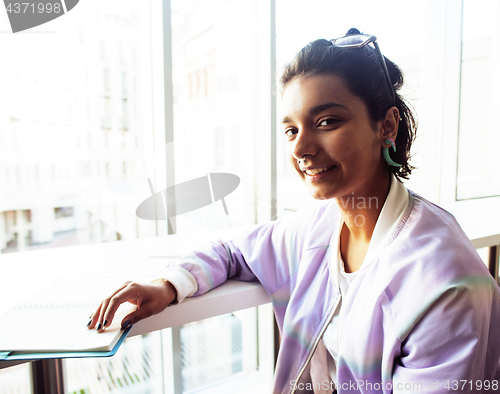 Image of young cute hipster girl student sitting in cafe with notebook re