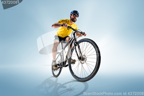 Image of The bicyclist on gray, studio shot.