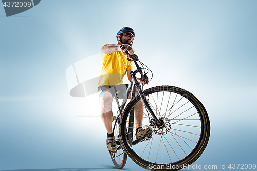 Image of The bicyclist on gray, studio shot.