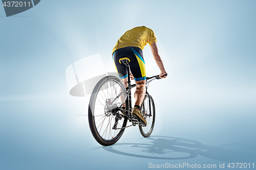 Image of The bicyclist on gray, studio shot.