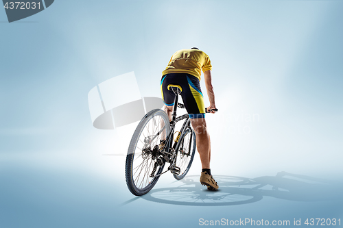 Image of The bicyclist on gray, studio shot.