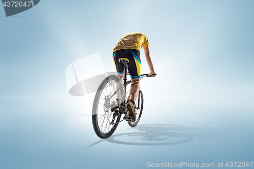 Image of The bicyclist on gray, studio shot.