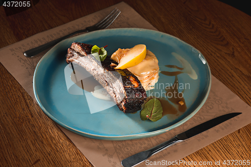 Image of grilled pork ribs on dark plate