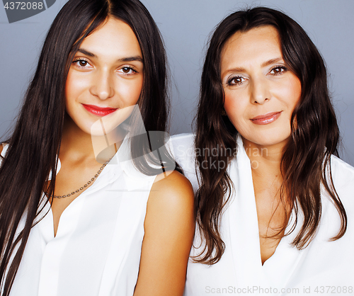 Image of cute pretty teen daughter with mature mother hugging, fashion st