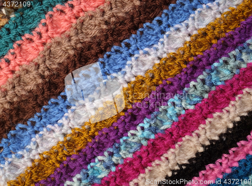 Image of Diagonal stripes of crocheted stitches in multi-coloured wool ba