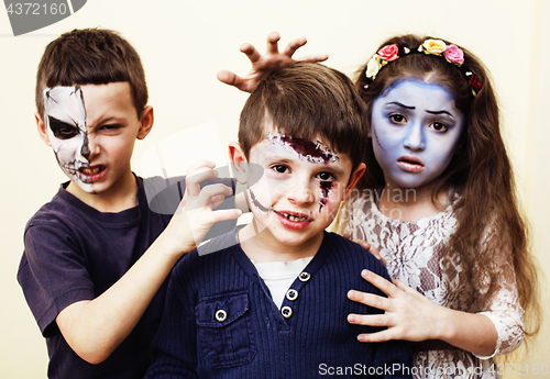 Image of zombie apocalypse real kids concept. Birthday party celebration facepaint on children dead bride, scar face, zombie skeleton together close up makeup emotional posing.