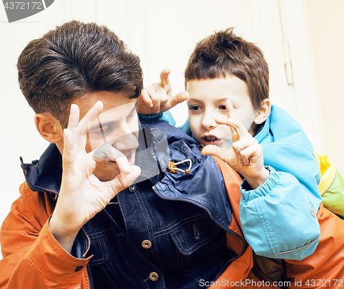 Image of young handsome father with his son fooling around at home, lifes