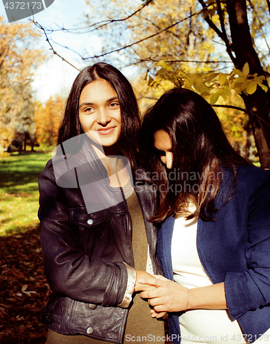 Image of mature real mother with daughter outside autumn fall in park