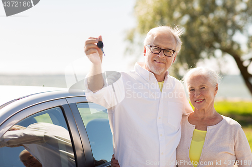 Image of happy senior couple with car key at seaside