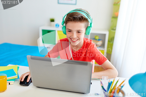 Image of boy in headphones playing video game on laptop