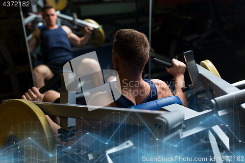 Image of man doing chest press on exercise machine in gym