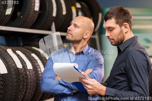 Image of customer and salesman at car service or auto store