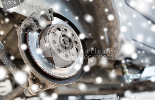 Image of car brake disc at repair station over snow