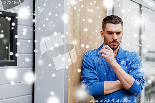 Image of auto mechanic smoking cigarette at car workshop