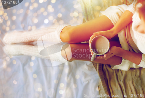 Image of close up of woman with cocoa cup in bed at home