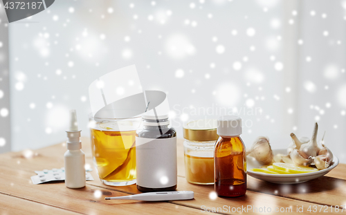 Image of drugs, thermometer, honey and cup of tea on wood