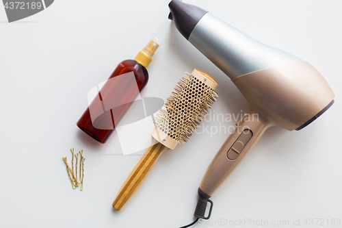 Image of hairdryer, brush, hot styling hair spray and pins