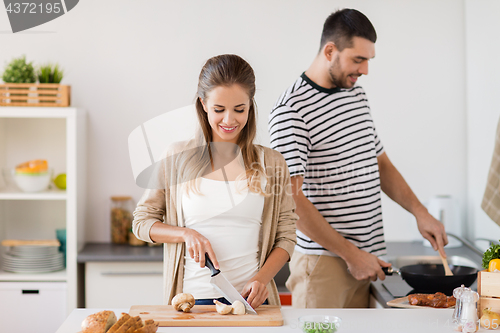 Image of couple cooking food at home kitchen