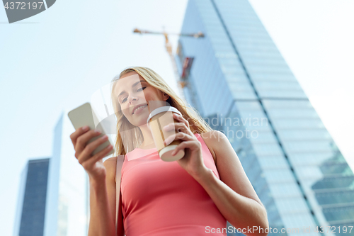 Image of woman with coffee and smartphone in city