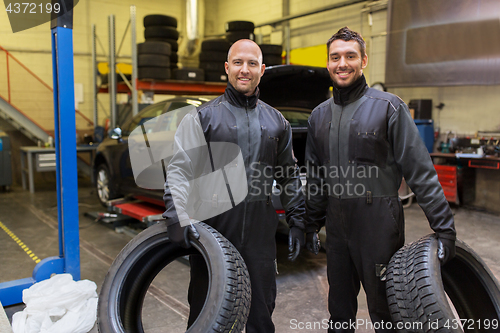 Image of auto mechanics changing car tires at workshop