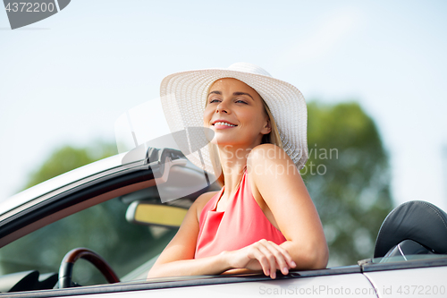 Image of happy young woman in convertible car