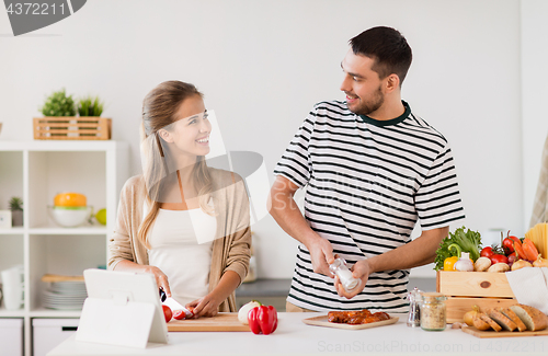 Image of happy couple cooking food at home kitchen