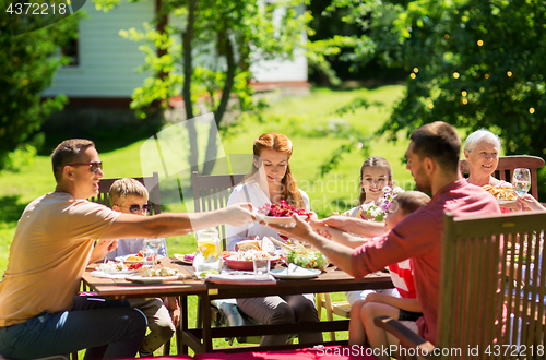 Image of happy family having dinner or summer garden party