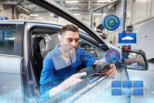 Image of mechanic man with diagnostic scanner at car shop