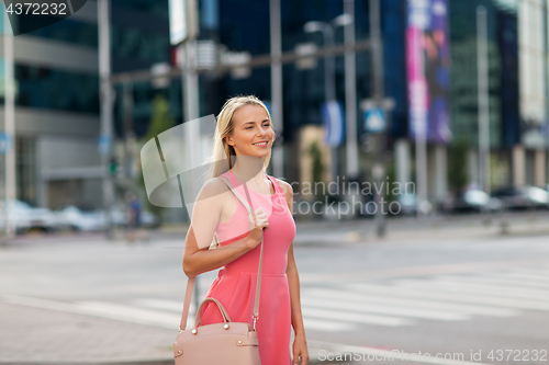 Image of happy smiling young woman on city street