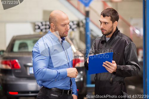 Image of auto mechanic and customer at car shop