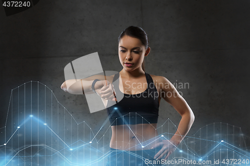 Image of young woman with heart-rate watch in gym