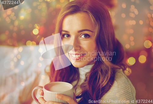 Image of happy woman drinking cocoa at home for christmas