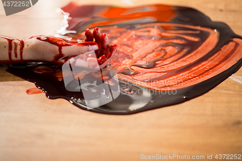 Image of dead woman hand in blood on floor at crime scene