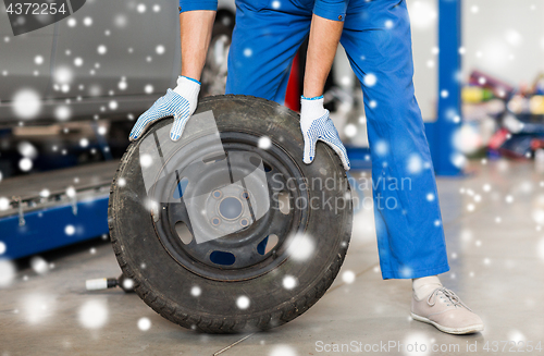 Image of auto mechanic changing car tire at workshop