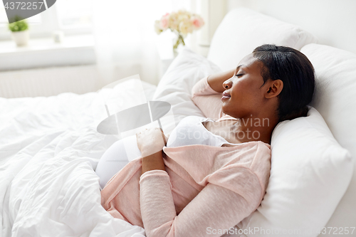 Image of pregnant african american woman sleeping at home