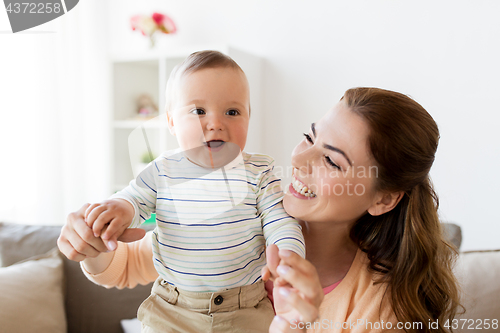 Image of happy young mother with little baby at home