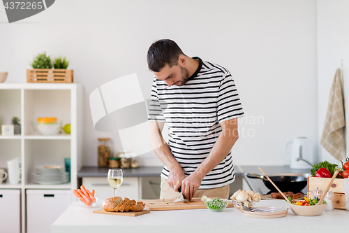 Image of man cooking food at home kitchen