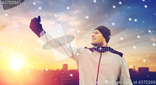 Image of man taking selfie with smartphone in winter 