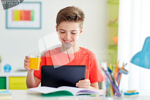 Image of student boy with tablet pc and juice at home