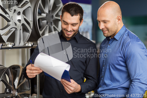 Image of customer and salesman at car service or auto store
