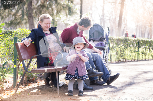 Image of Young family with cheerful child in the park.