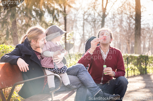 Image of Young family with cheerful child in the park.