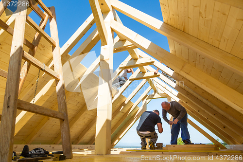 Image of Builders at work with wooden roof construction.