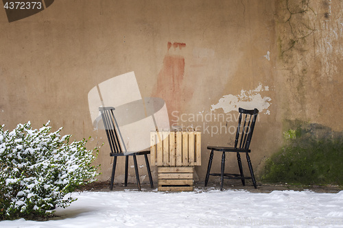 Image of table and two chairs near the wall