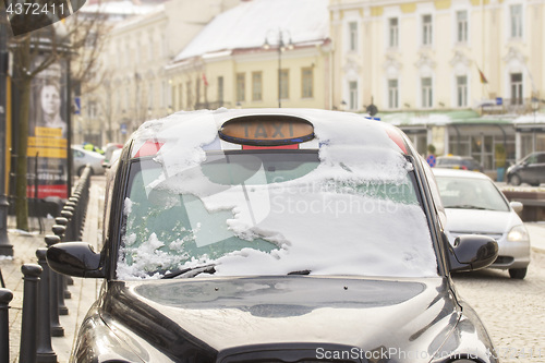 Image of Black city taxi cab in snow